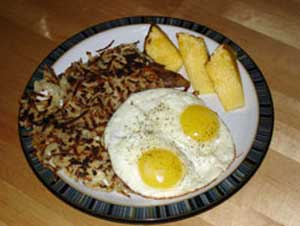 Hashbrowns served with eggs and pineapple spears
