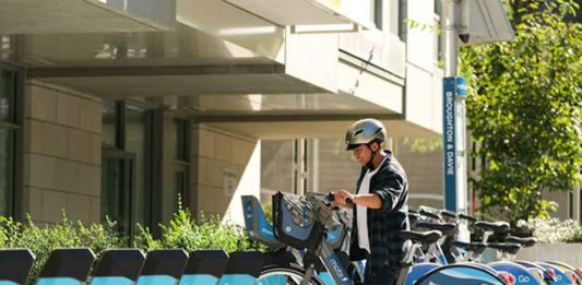 A Mobi user starts an e-bike trip at a Mobi e-station.